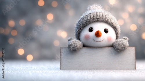Cute snowman with a gray hat peeking over a blank sign board on snowy winter blurred background, banner with copy space
