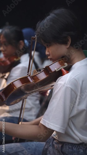 Close-Up of Young Violinist Performing in Orchestra Rehearsal