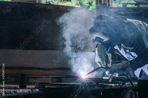 Industrial welder welding fabricated construction in factory, Welding process by Flux Core Welding, FCAW