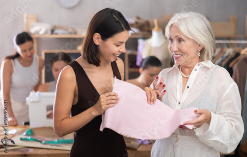 Canvas Print During sewing session, young female participant holding paper pattern pinned to