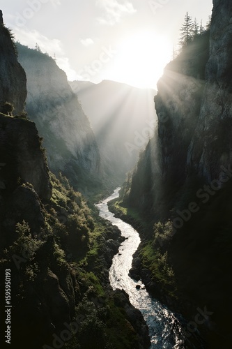River Flowing Through Deep Rocky Valley with Sunlight and Mist
