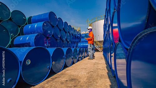 Male worker inspection record drum oil stock barrels blue horizontal