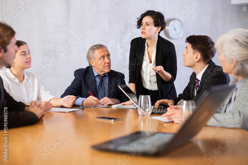 Female director gives instructions to managers in the deliberation room