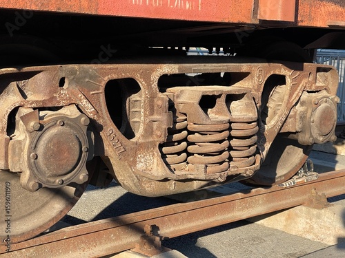 Canvastavla A close-up of a rusted train bogie with visible springs and wheel assemblies, il