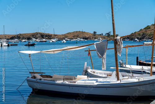 Spanish traditional fishing or guide tour boat moored near the Dali Museum in Portlligat fish village. Sunny and calm day out on the water - best summer activity concept. 