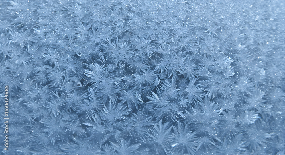 Fototapeta premium Stunning close up shot of frost forming intricate patterns on a cold winter windowpane, showcasing nature's delicate artistry in freezing temperatures.