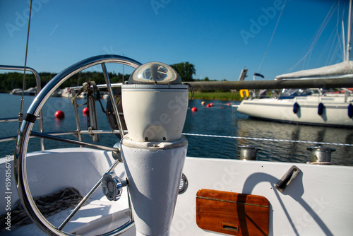 Sailing Compass and Wheel with View of Yacht Harbor in Summer