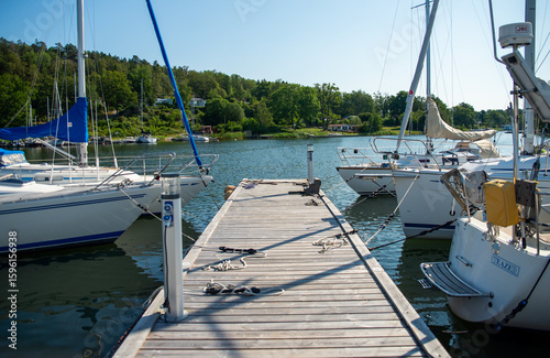 Wooden Pier with Sailboats in Marina on a Sunny Day