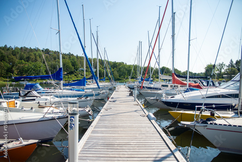 Wooden Pier with Sailboats in Marina on a Sunny Day
