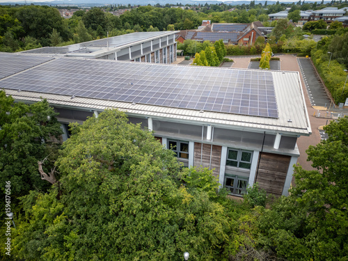 Aerial View of Modern Eco-Friendly Office or Campus Building with Solar Panels and Surrounding Green Trees