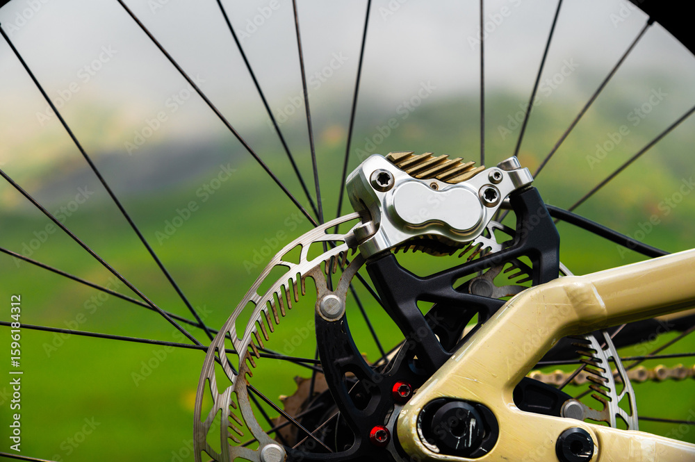 Obraz premium Close-up of a mountain bike brake system. Close-up of the rear wheel. Brake disc and caliper of a mountain bike hydraulic brake system