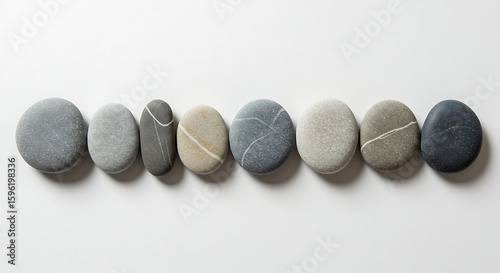 A row of smooth, rounded stones arranged on a white surface.
