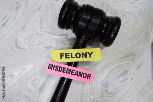 Slika na platnu Concept of Felony misdemeanor write on sticky notes with gavel isolated on Wooden Table