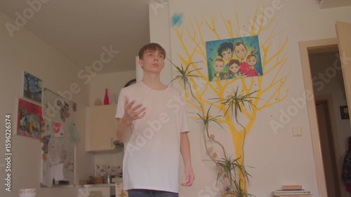A heartwarming video shows a young boy dancing joyfully in a cozy living room, followed by a young man dancing too, emphasizing family bonds