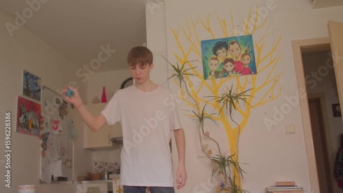 In a cozy living room with a family picture, a young man navigates activities showcasing family dynamics, with a young boy joyfully dancing