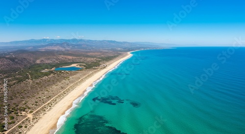 Aerial View of Sandy Beach Meeting Turquoise Ocean Under Clear Sky