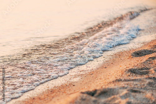 Fototapeta Naklejka Na Ścianę i Meble -  Sea foam at sandy beach in summer sunrise, coastline of Kassandra peninsula at Chalkidiki, Greece