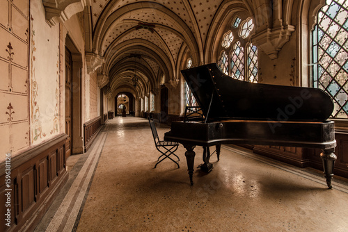 Abandoned grand piano in a historic, decaying castle corridor with gothic arches and stained glass windows, capturing beauty in forgotten elegance