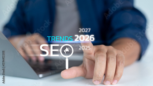 Close-up hand pointing to SEO Trends 2026 text with digital years timeline. Concept of future search engine optimization, marketing forecast, and online strategy.