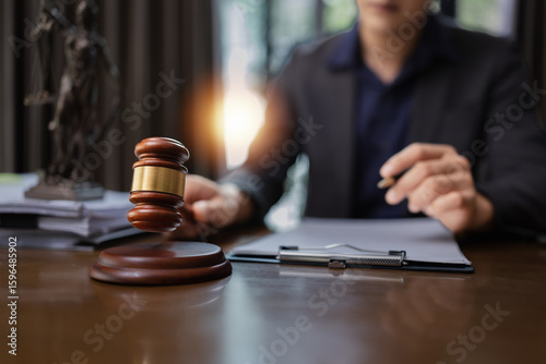 Lawyer Holding Hammer with Document Paper on Wood table,  Law, Justice Symbol,