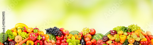 Photo fresh various fruits, vegetables and berries on green background.