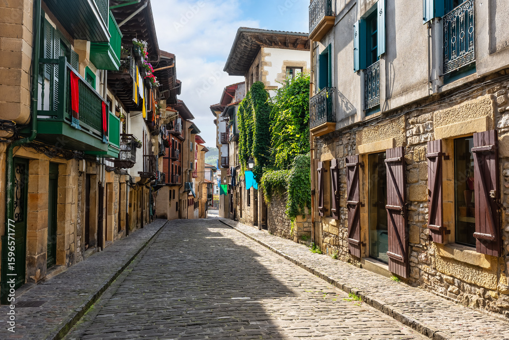 Fototapeta premium Typical cobbled streets with wooden balconies with flowers in the picturesque village of Hondarribia, Basque Country, Spain.