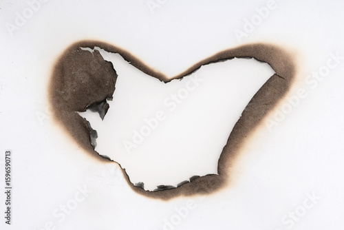 Burnt hole isolated on white paper. burns borders paper close up. Paper burn black stain mark close up.
