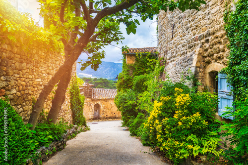Fototapeta Naklejka Na Ścianę i Meble -  Charming street in quaint Menerbes village with colorful buildings and vibrant flowers. Village of Menerbes (Most Beautiful Village in France) in the Luberon mountains, France, Luberon, Vaucluse.