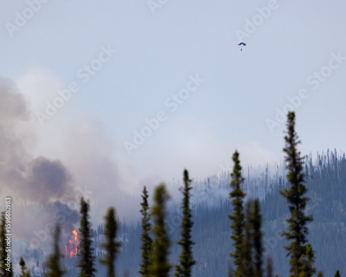 A smokejumper parachutes into a wildfire.