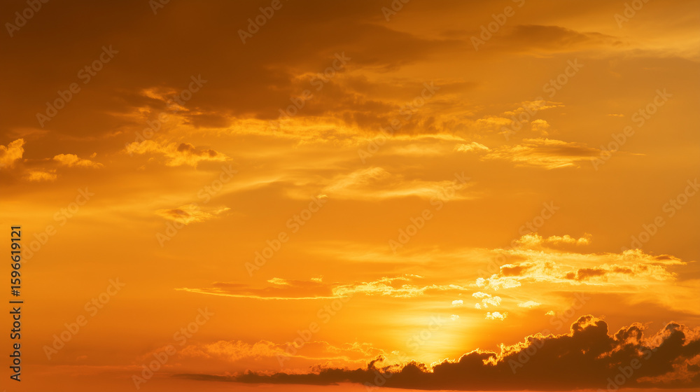 Fototapeta premium Golden orange sky landscape with warm tones and soft clouds. Perfect for nature, sunset, sunrise, and atmospheric backgrounds evoking calm, beauty, and inspiration.