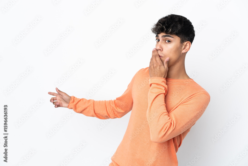 Obraz premium Young man over isolated white background with surprise expression while pointing side
