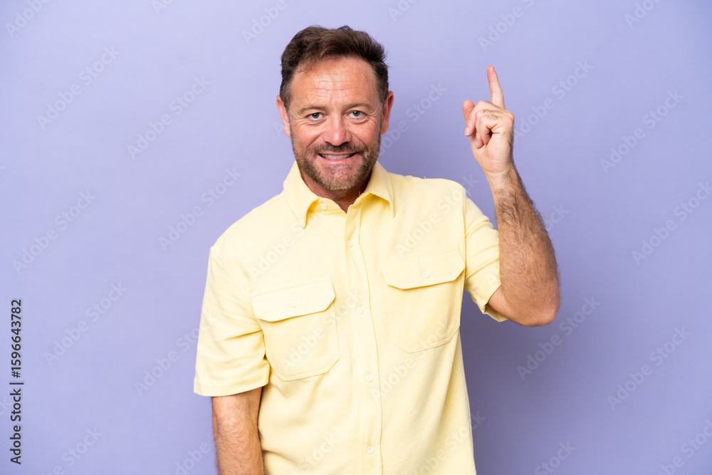 Fototapeta premium Middle age caucasian man isolated on purple background happy and pointing up