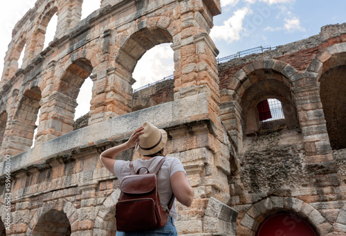 Photography Traveler girl with hat and bag looking at Verona Arena,  tour tourism, travel,va