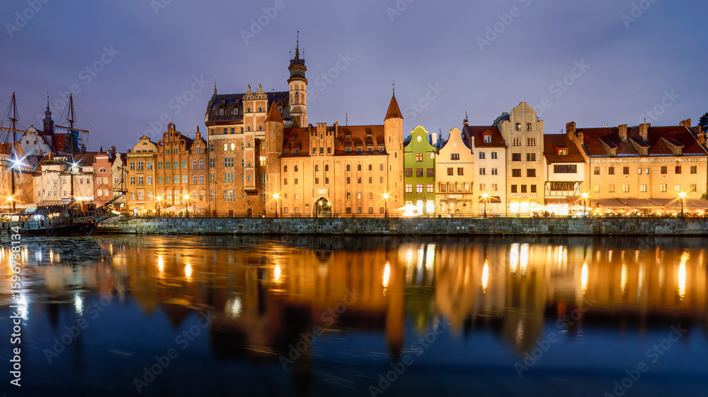 Gdansk waterfront at night glows with historic elegance — a moored galleon and golden reflections mirror the city’s seafaring soul beneath a tranquil Baltic sky. Gdansk waterfront at night glows with historic elegance — a moored galleon and golden reflections mirror the city’s seafaring soul beneath a tranquil Baltic sky.