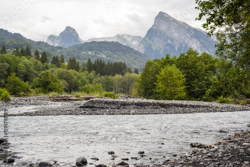 Mountain range above a forest a river in a beautiful dramatic landscape
