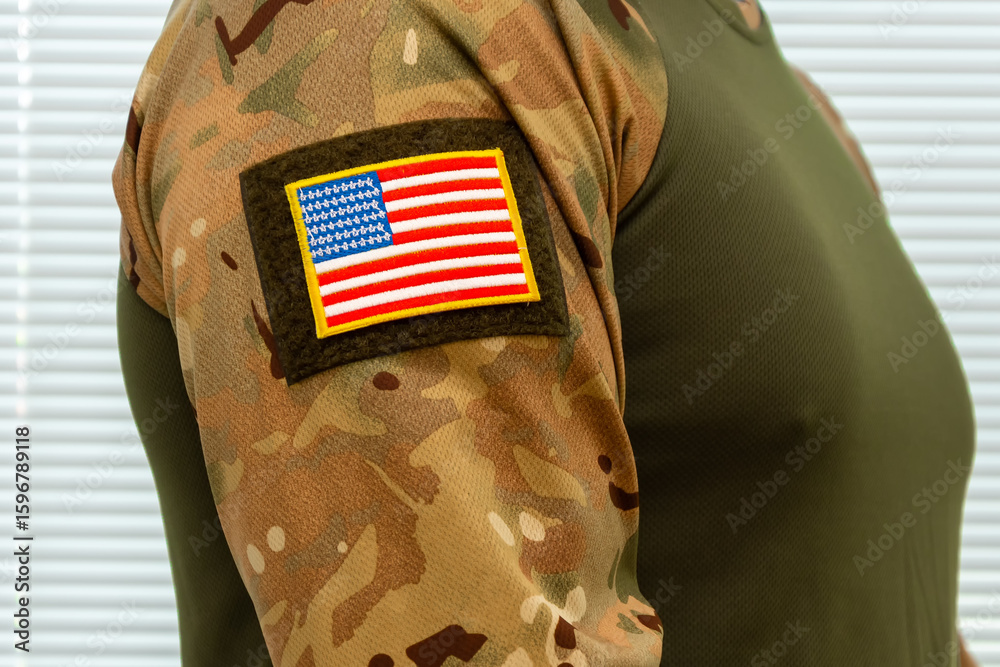 Obraz premium US military uniform with US flag patch on the sleeve. Camouflage and a symbol of patriotism.