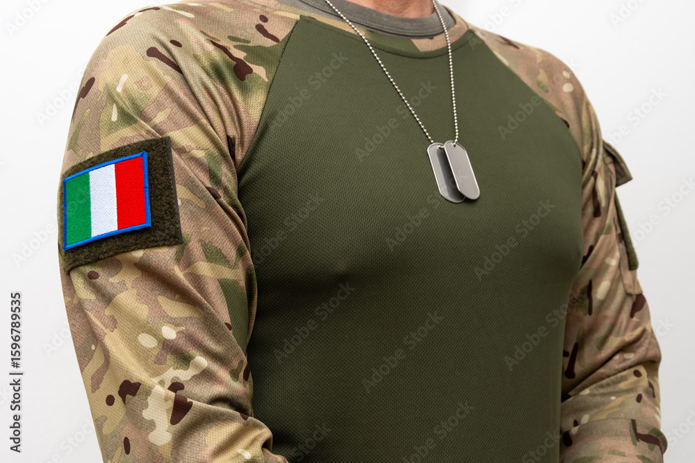 Fototapeta premium A soldier in camouflage with an Italian flag patch and army badges around his neck.