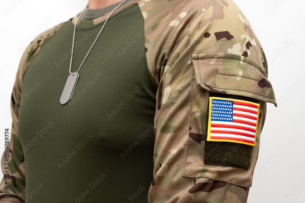 Obraz premium Soldier in army clothing with US flag patch and army dog tags on his chest.