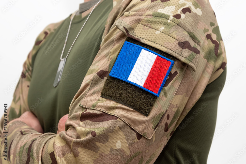 Obraz premium French soldier in uniform with camouflage and identification badges on white background.