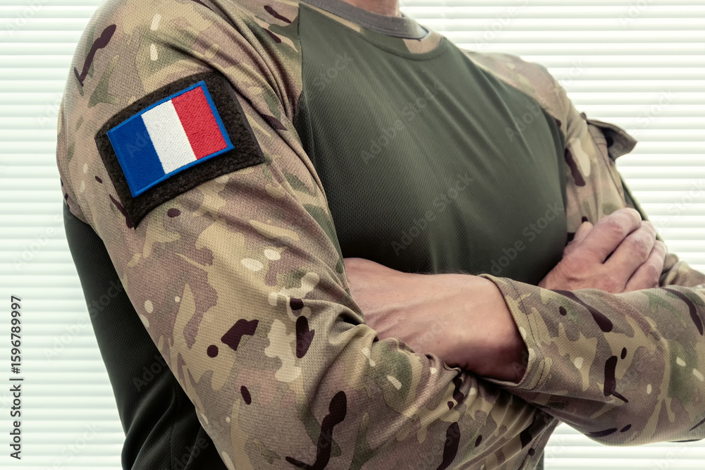 Fototapeta premium Soldier with French flag on military uniform, white background.