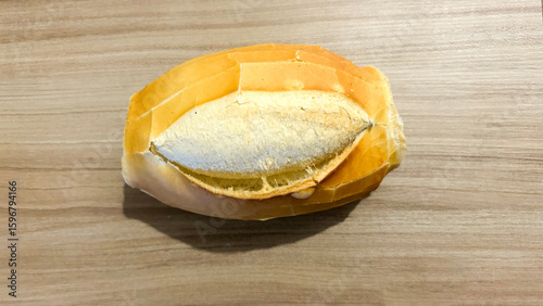 Small french bread loaf resting on wooden table