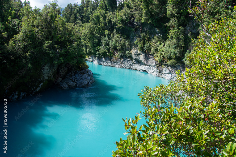 Fototapeta premium Turquoise River Surrounded by Lush Greenery