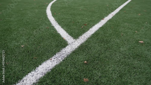 Bright white lines mark fresh green football grass. Even paint guides structured gameplay and teamwork drills during friendly matches