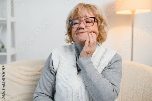 Εκτύπωση καμβά Senior woman experiencing tooth pain, holding his cheek with pained expression,