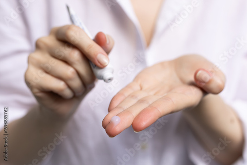 Closeup of a woman applying prescription retinoid.
