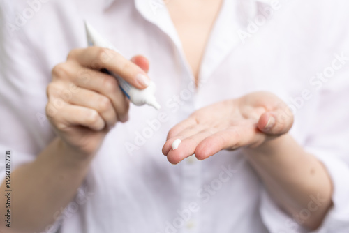 Closeup of a person using topical treatment with azelaic acid for acne and hyperpigmentation.