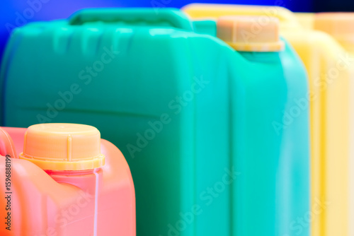 Row of plastic containers in various colors.  containers are lined up next to each other. colors of containers are blue, green, yellow, and red. industrial production
