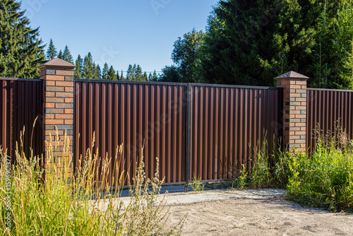 Fényképezés Corrugated board fence with brick pillars