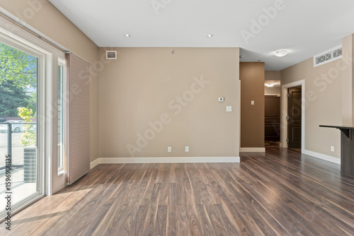 Tableau sur toile Large open living room with a tan wall and wooden floors