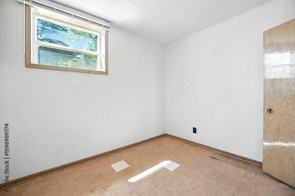 Fototapeta premium Small, empty room with a window and a door